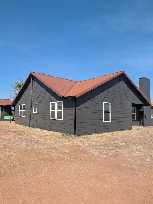 Dark grey steel home with a rust-red roof