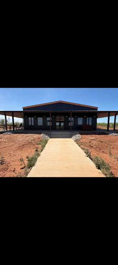 Steel home with a wide front porch and concrete walk