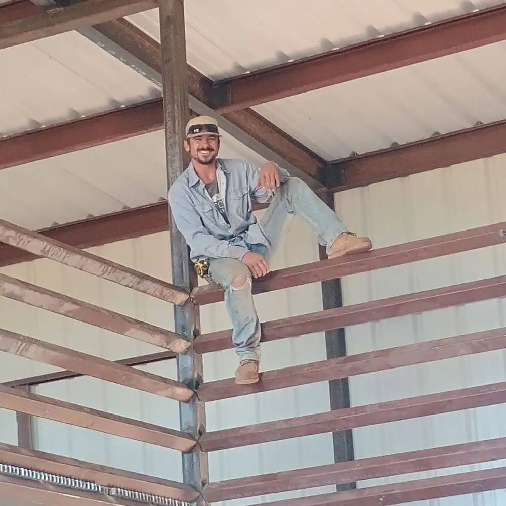 Randon Ragsdale sitting on the steel purlins inside one of his buildings