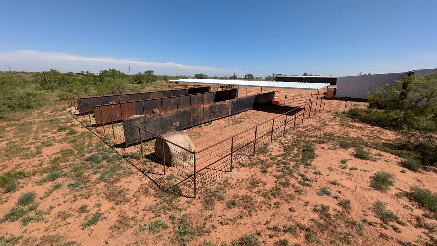 Pipe fence pens and a shed on the ranch, seen from above